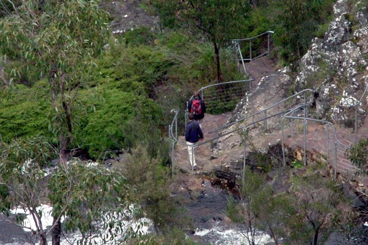 a couple of people walking up a trail on a mountain