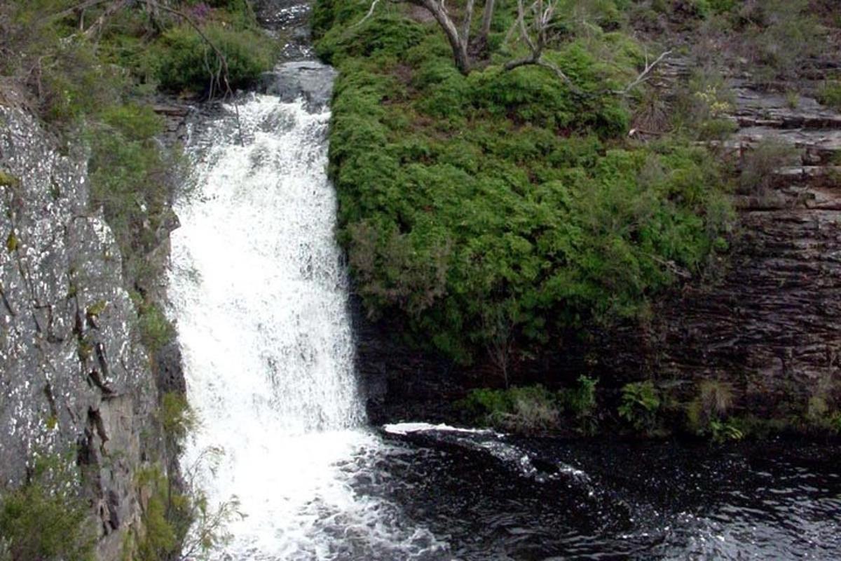 a waterfall on the side of a river