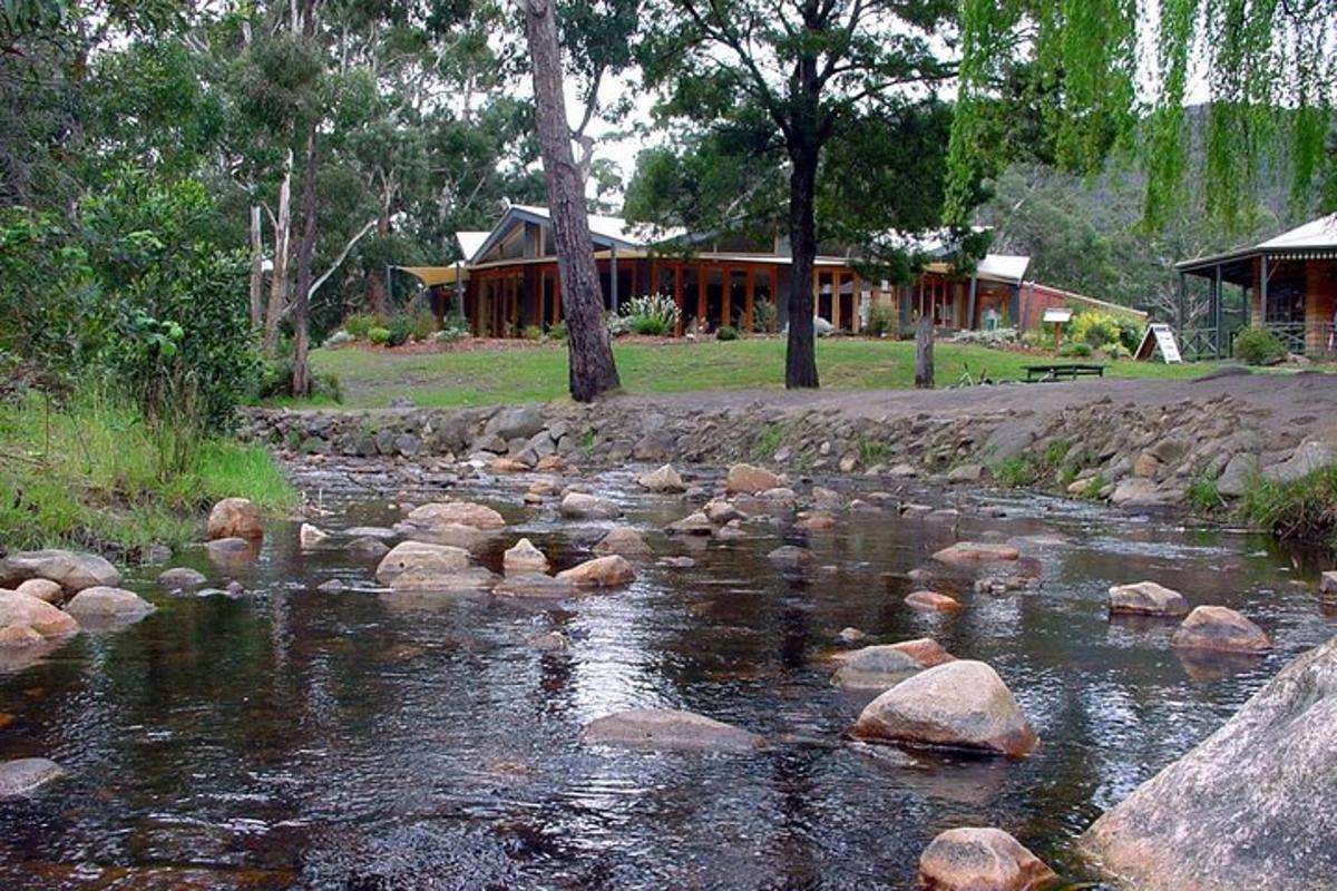 a river with rocks in front of a house