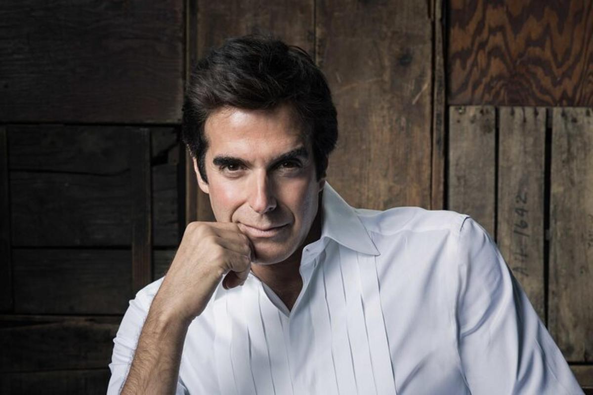 a man in a white shirt with his hand on his chin
