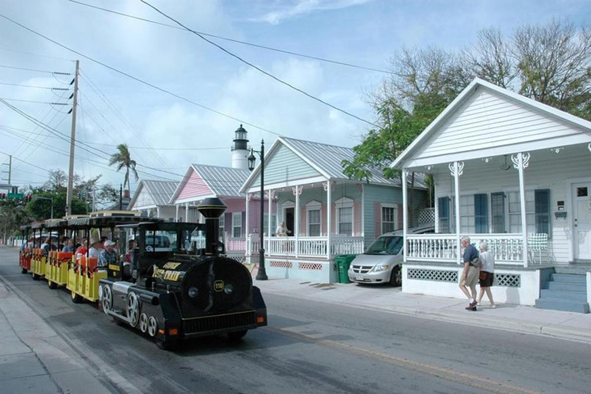 a small train with people riding on it on a street