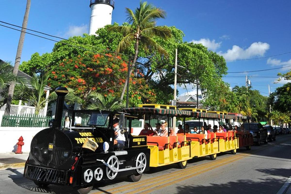 a small black and yellow train with people on it