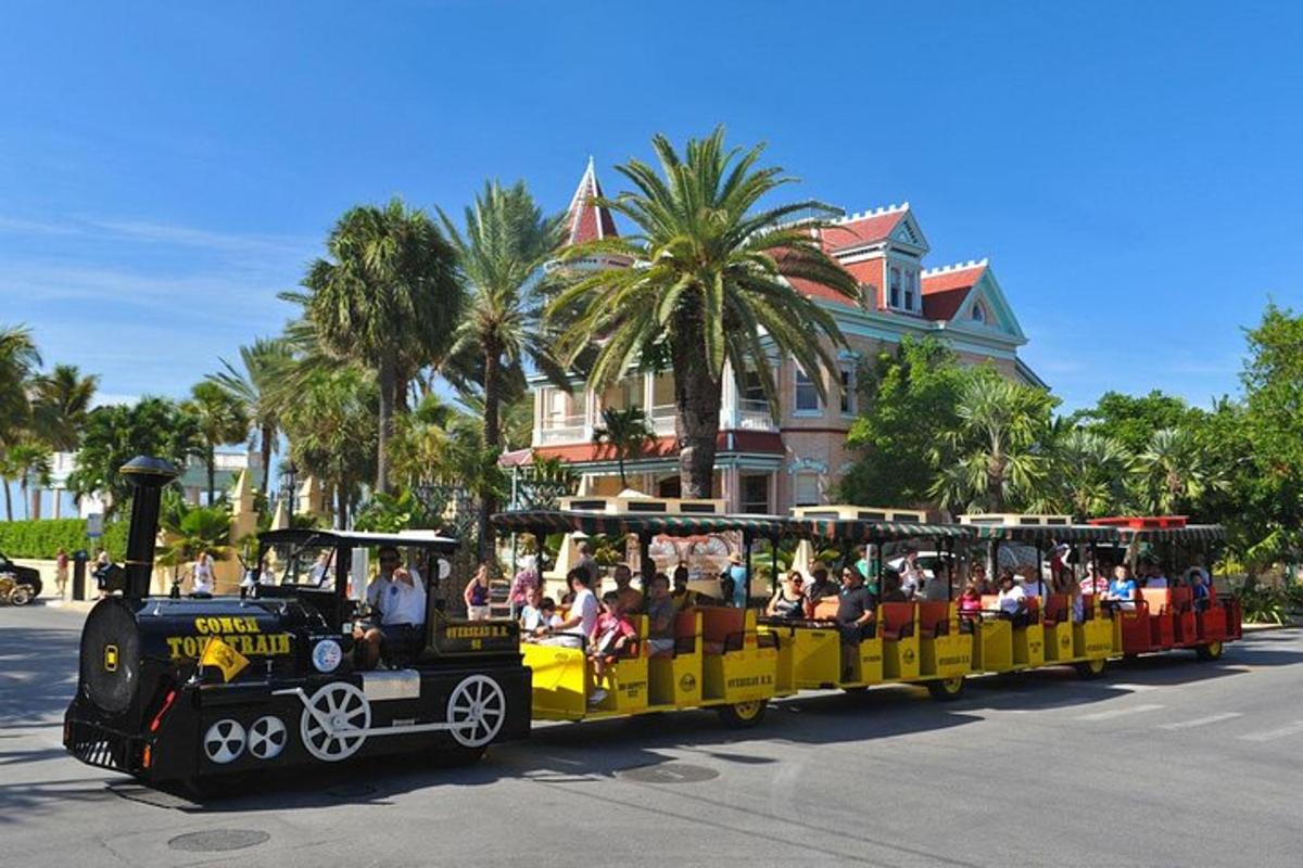 a small train filled with people riding on the street