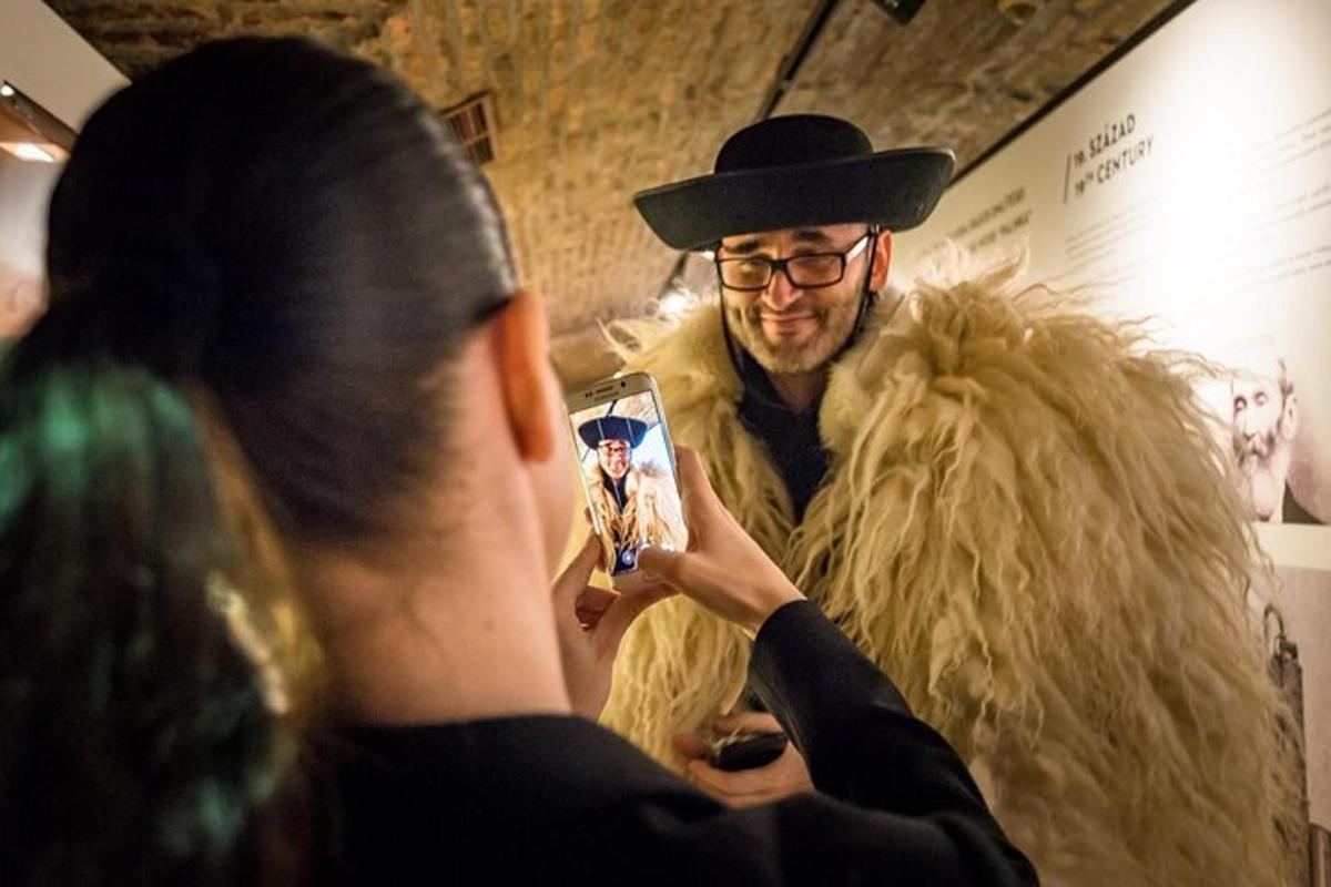 a man in a hat taking a picture of a man in a chair