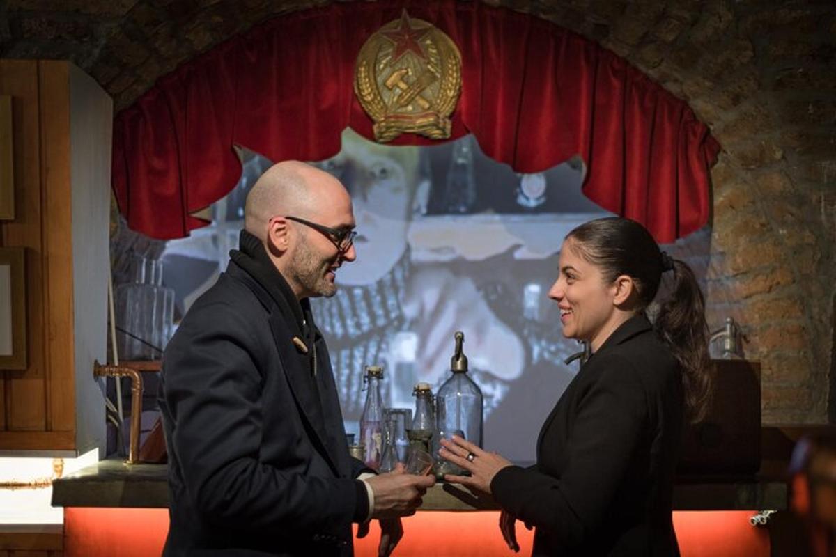 a man and a woman standing in front of a table with drinks