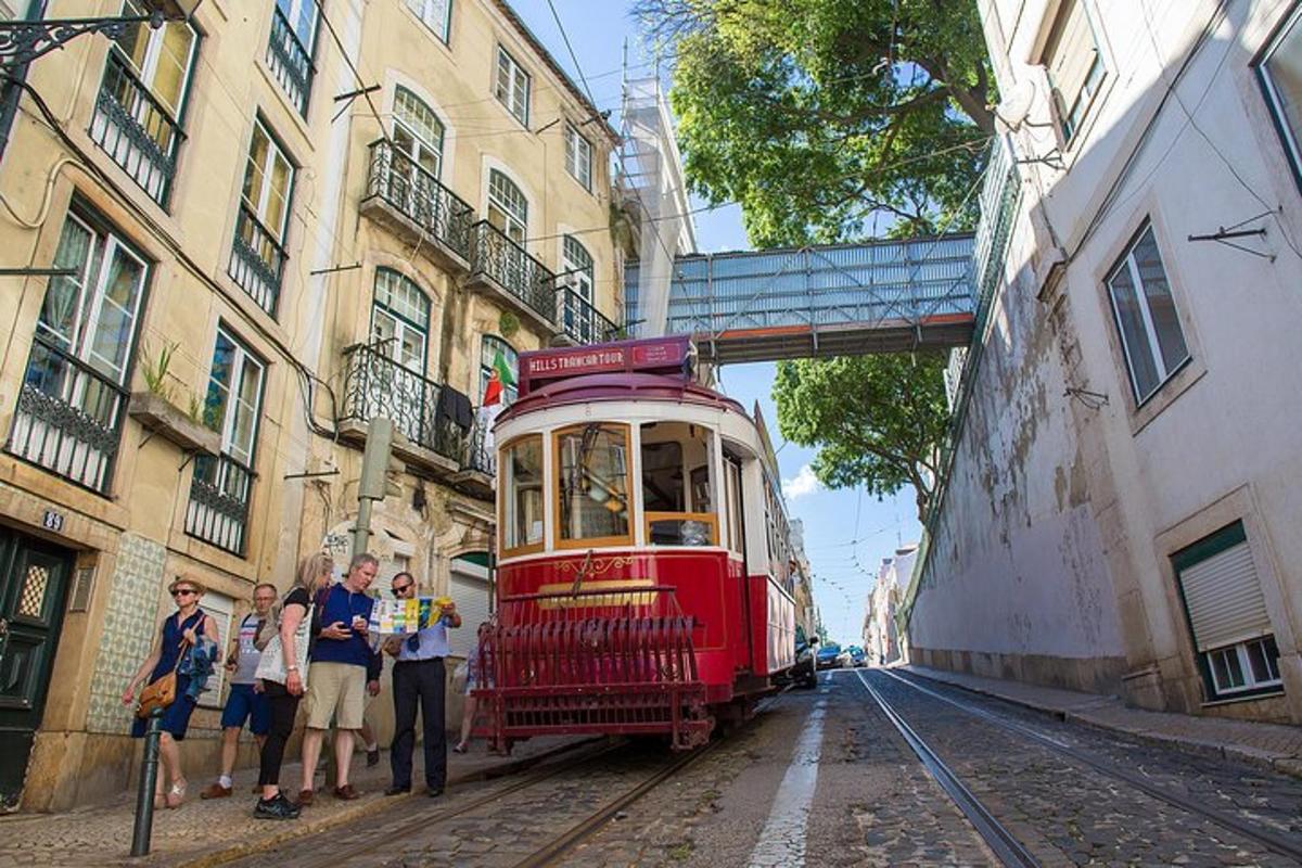 skupina lidí stojící vedle červené tramvaje