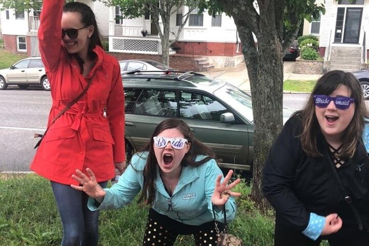 a group of three women standing next to a tree