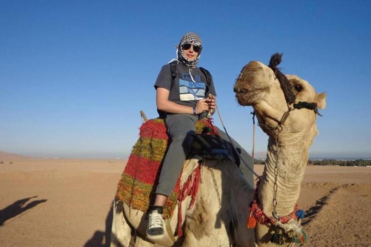 a woman riding a camel in the desert