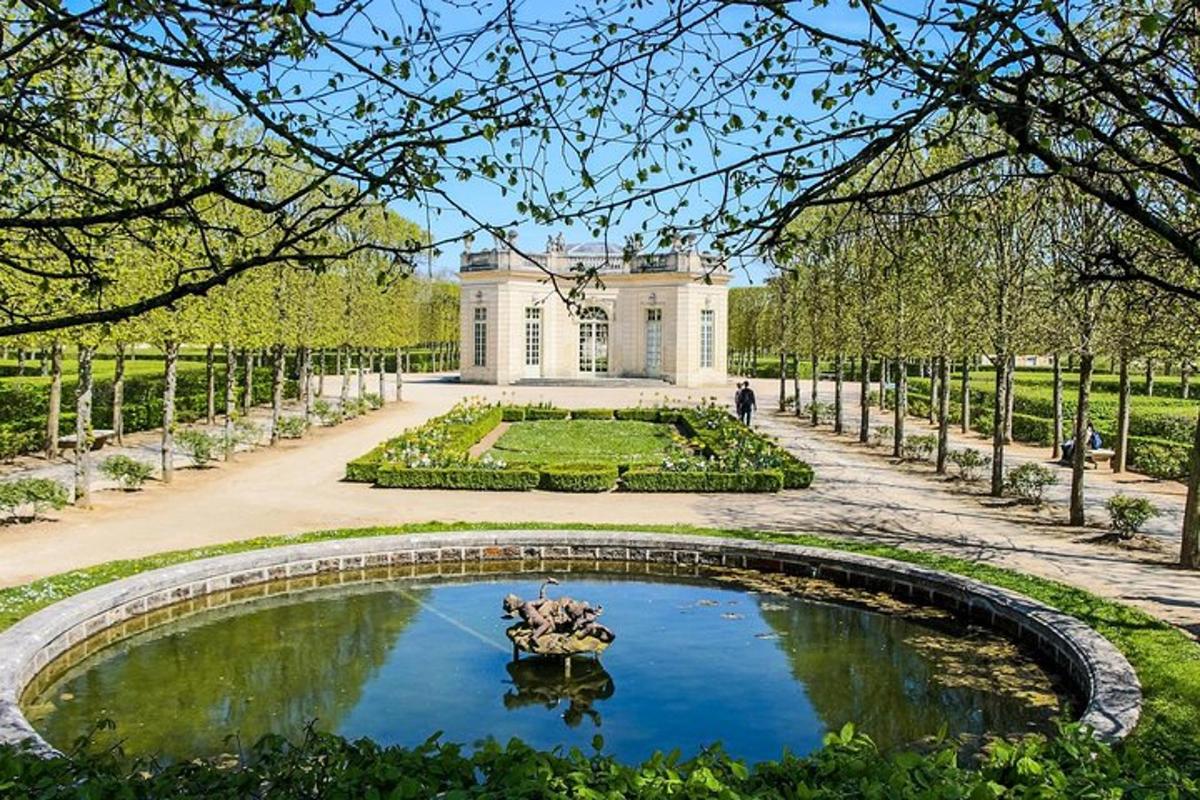 a garden with a pond in front of a building