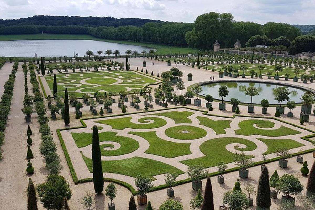 an aerial view of a garden with trees and a lake
