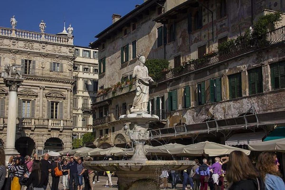 una folla di persone che camminano intorno a una fontana in una città
