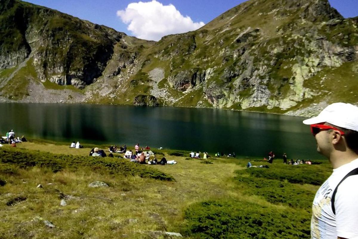 un uomo in piedi di fronte a una montagna con un lago