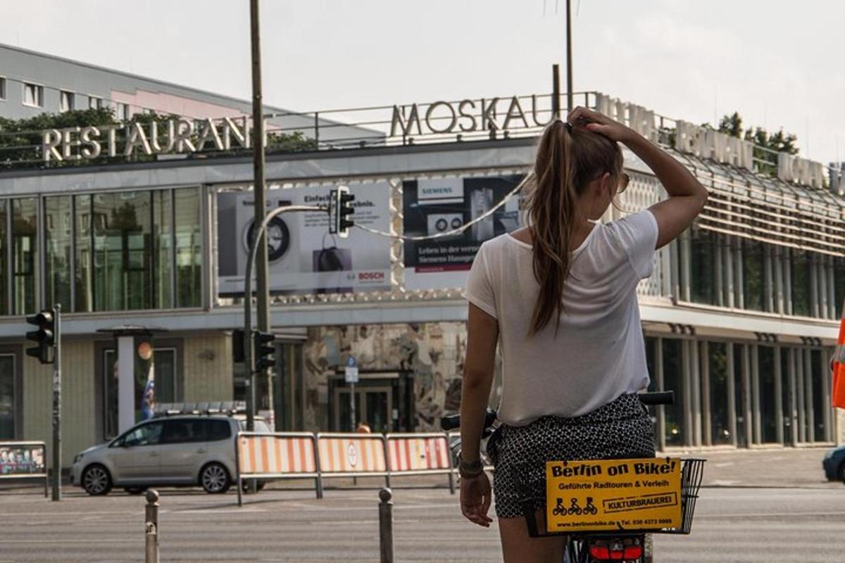 a woman is standing on a bike on a street