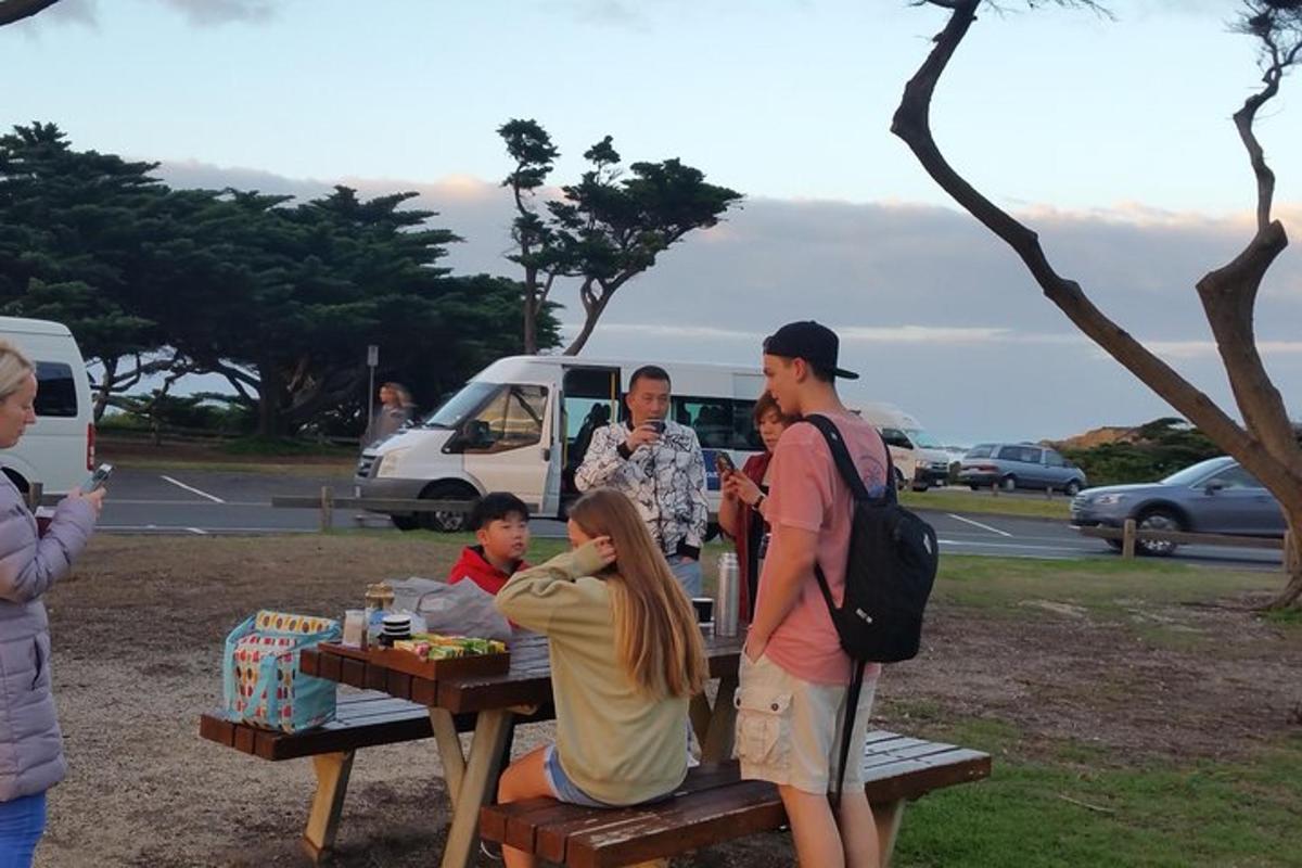 Un grupo de personas de pie alrededor de una mesa de picnic.