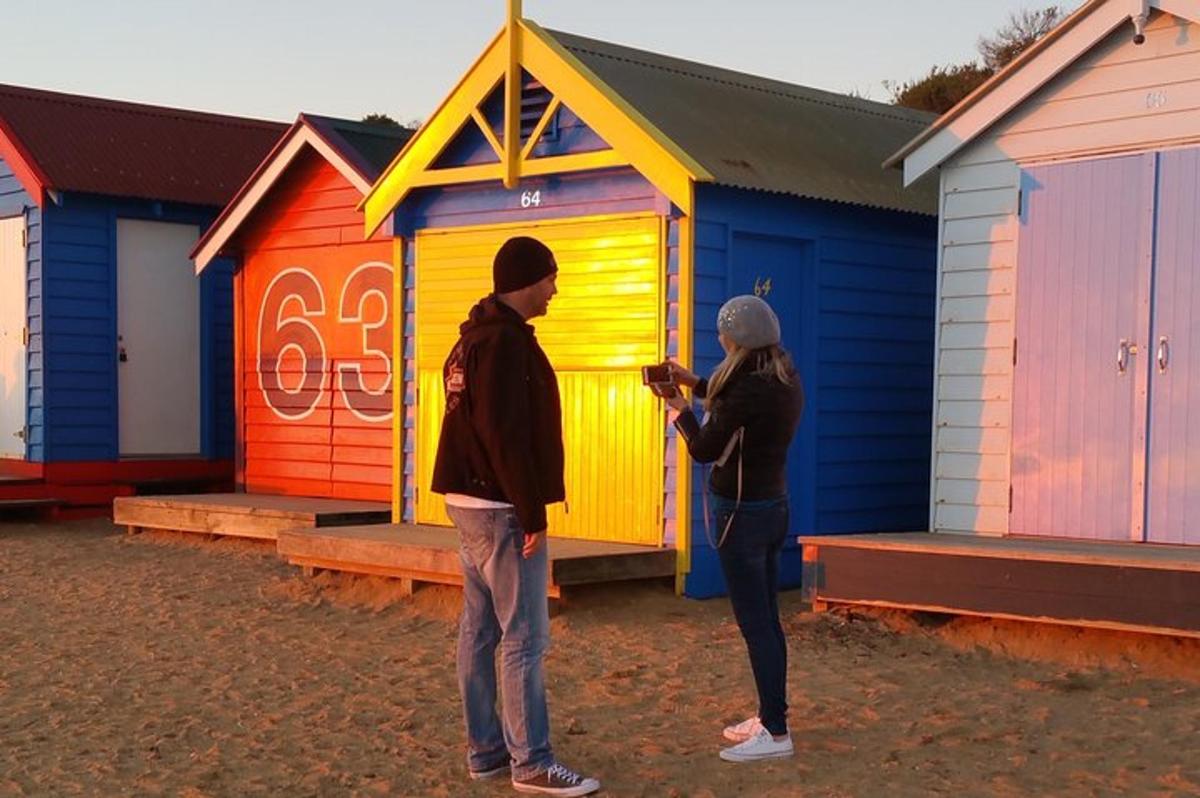 Tveir menn standa fyrir framan röð af strandskálum