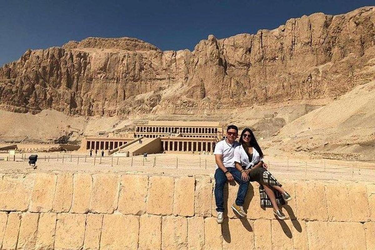 bir dağın önündeki duvarda oturan bir erkek ve bir kadın