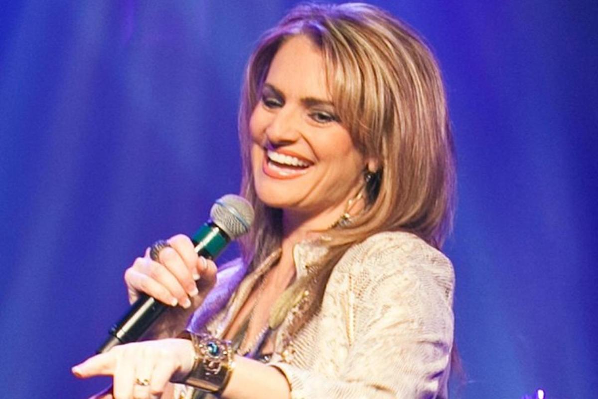 a woman singing into a microphone on a stage