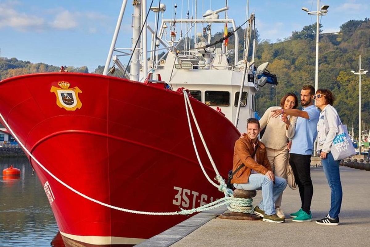 a group of people standing next to a red boat