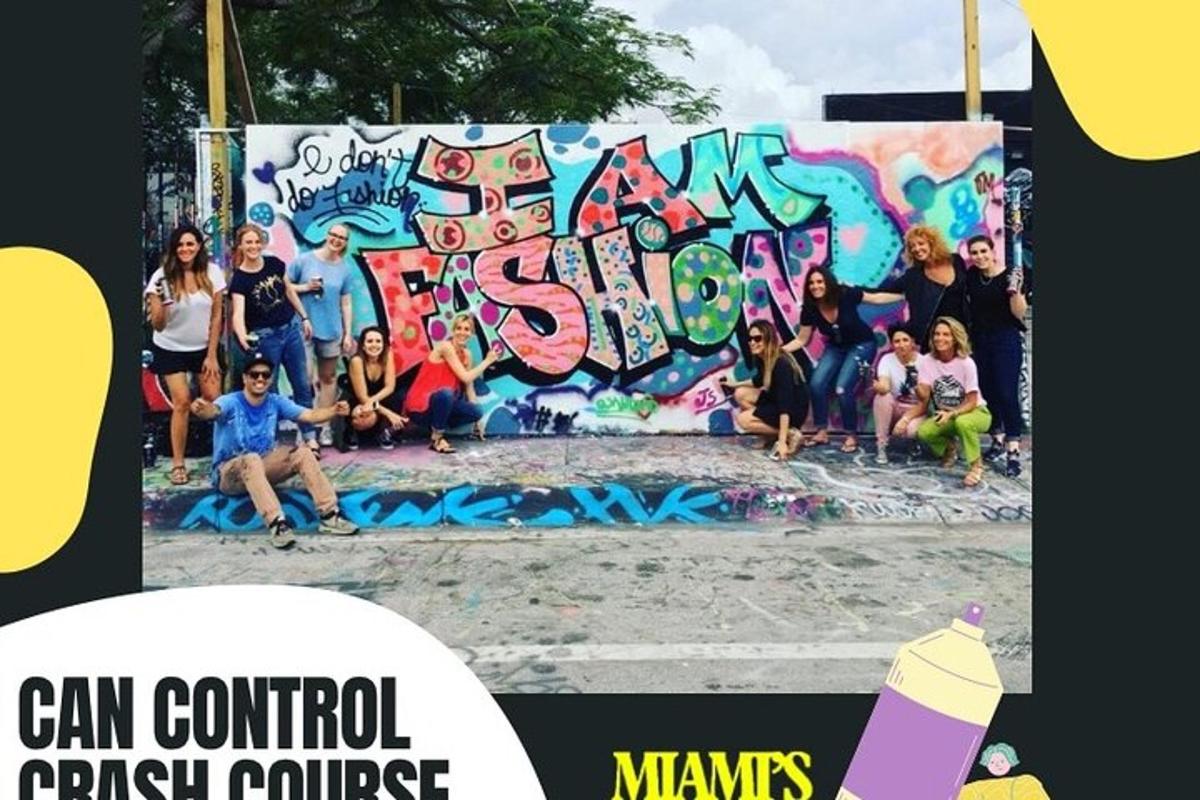 een groep mensen die voor een muur met graffiti zitten