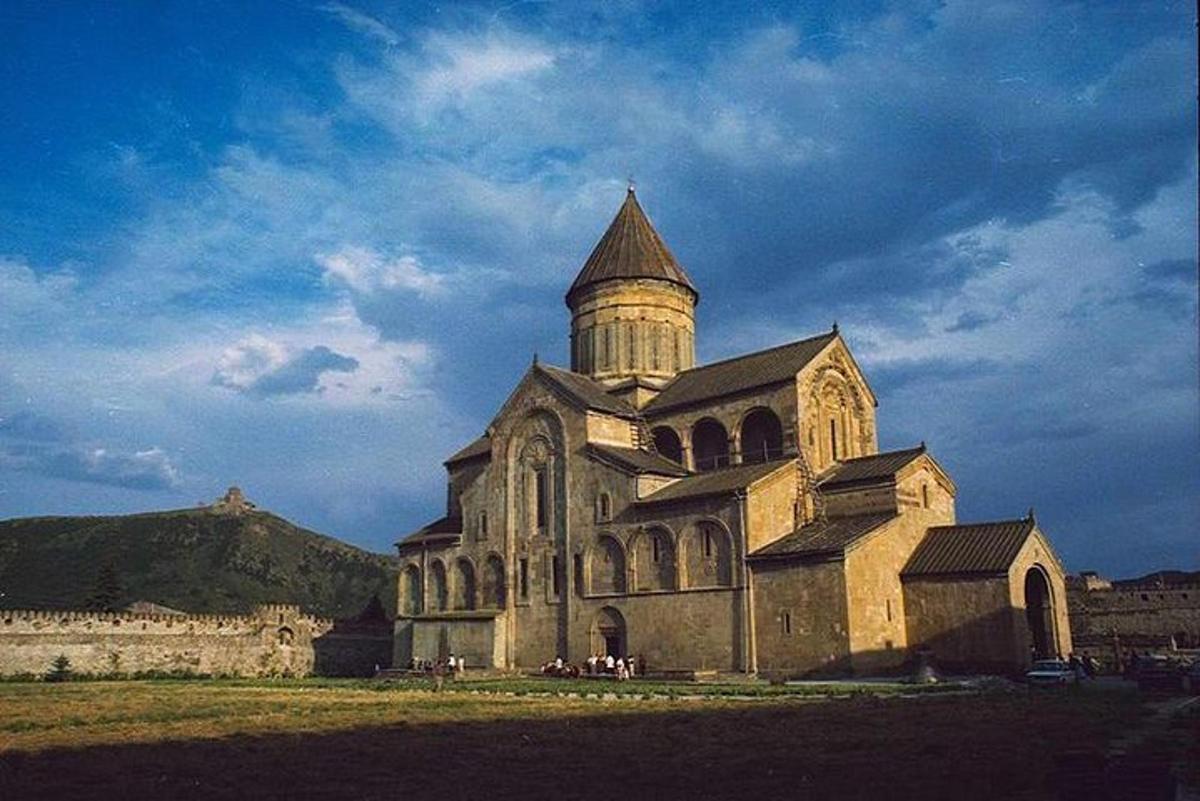 Una antigua iglesia con una torre en un campo