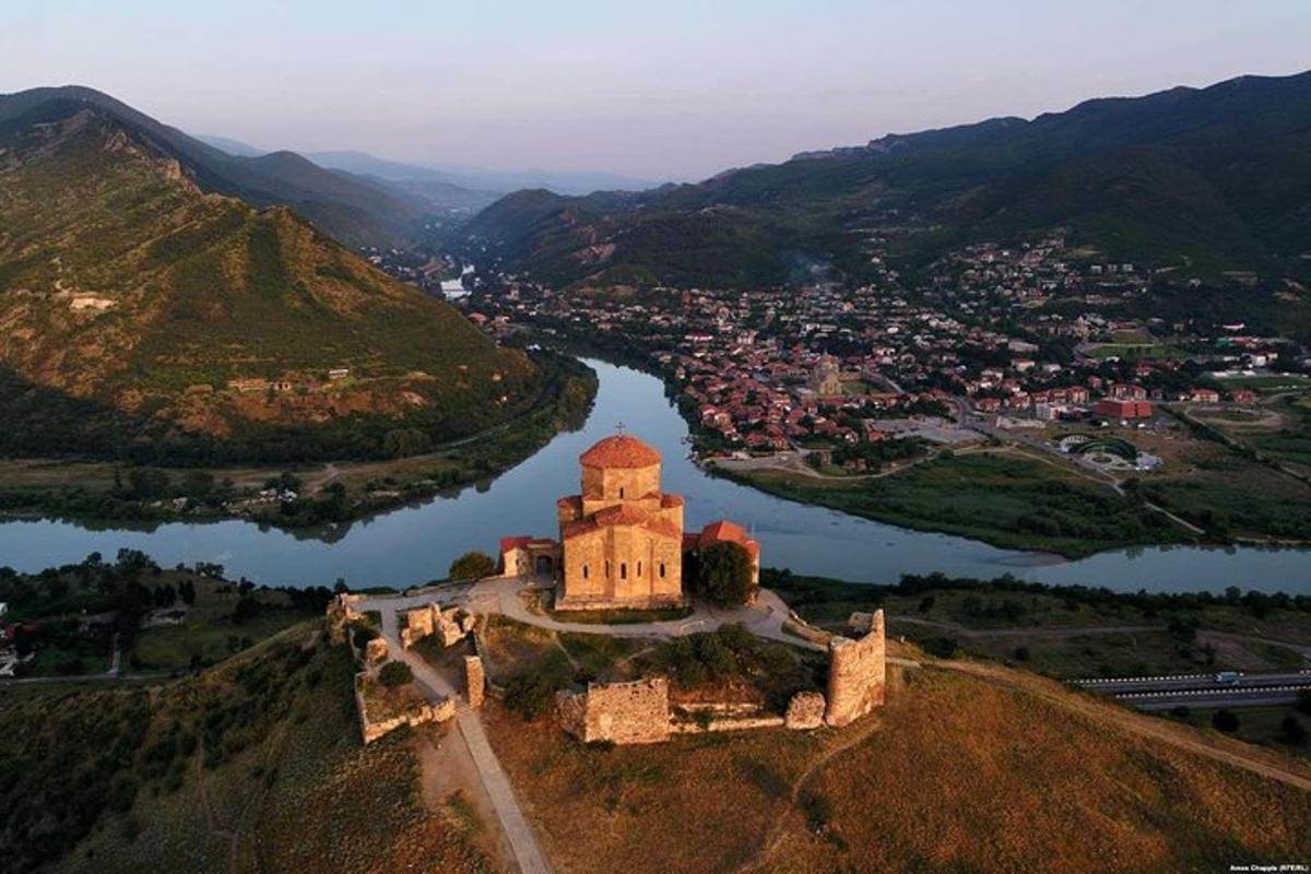 un castillo en la cima de una colina con un río