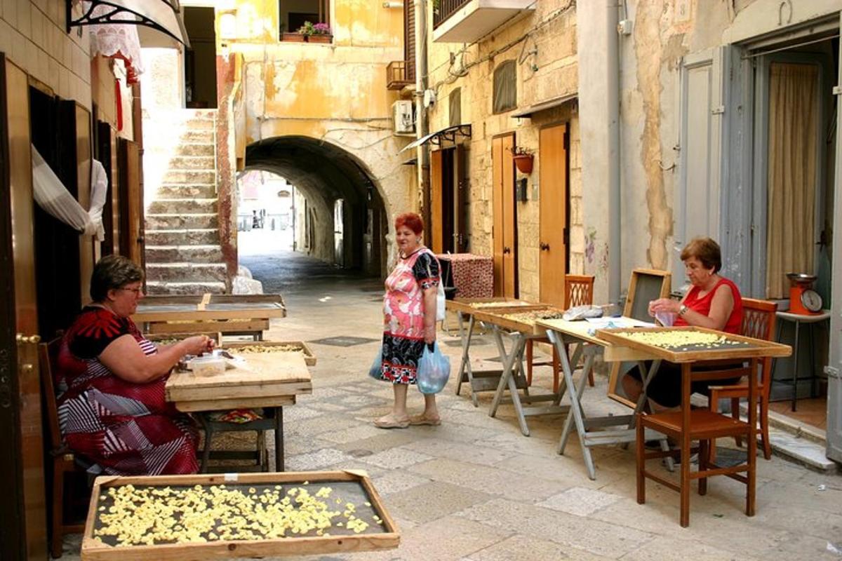 a group of people sitting at tables in an alley