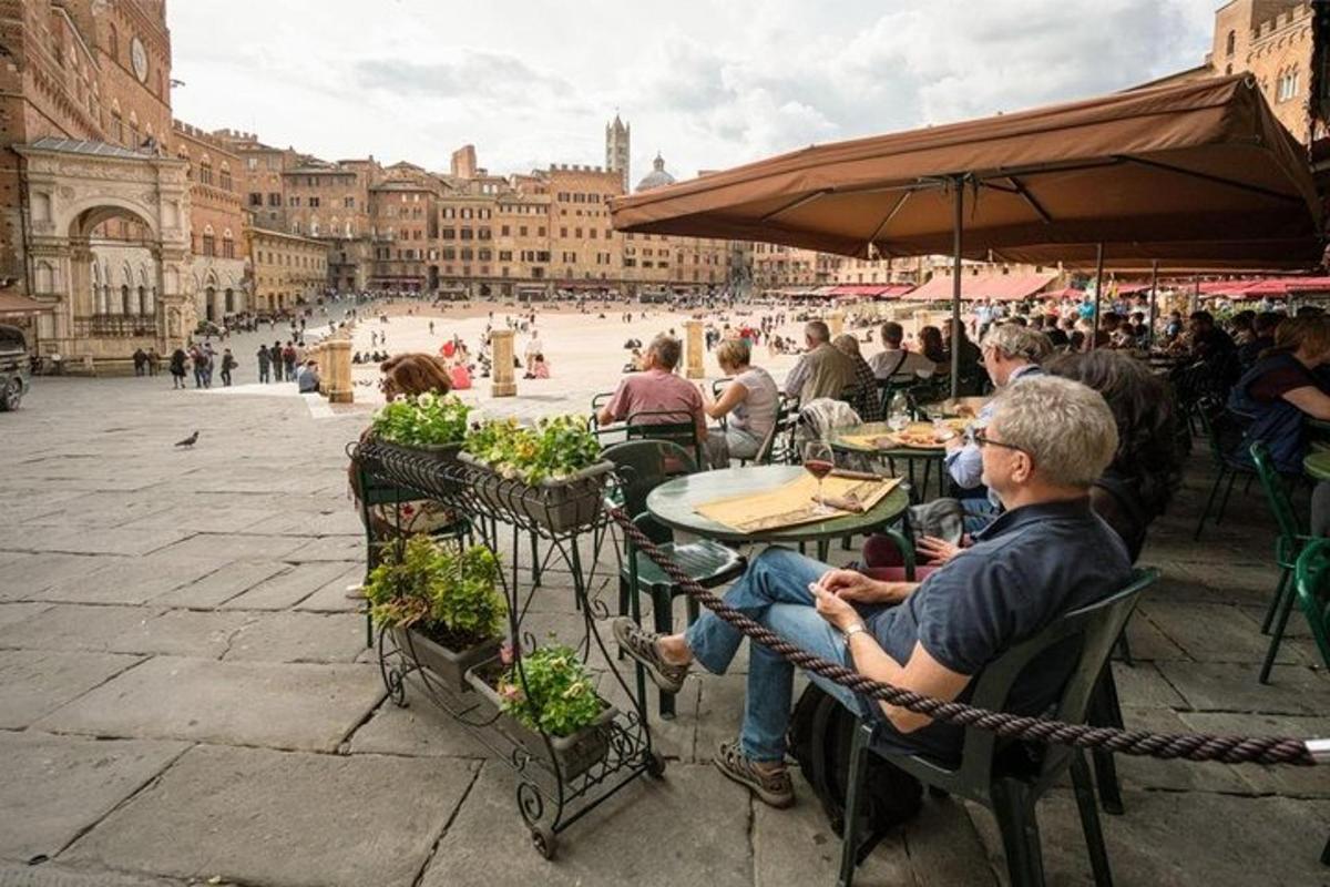 un gruppo di persone sedute ai tavoli in una strada cittadina