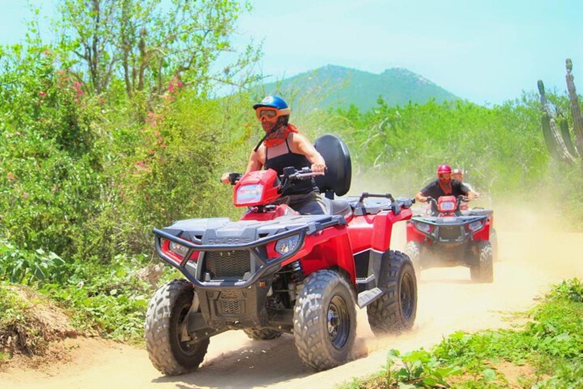 dua orang menaiki atv di jalan tanah