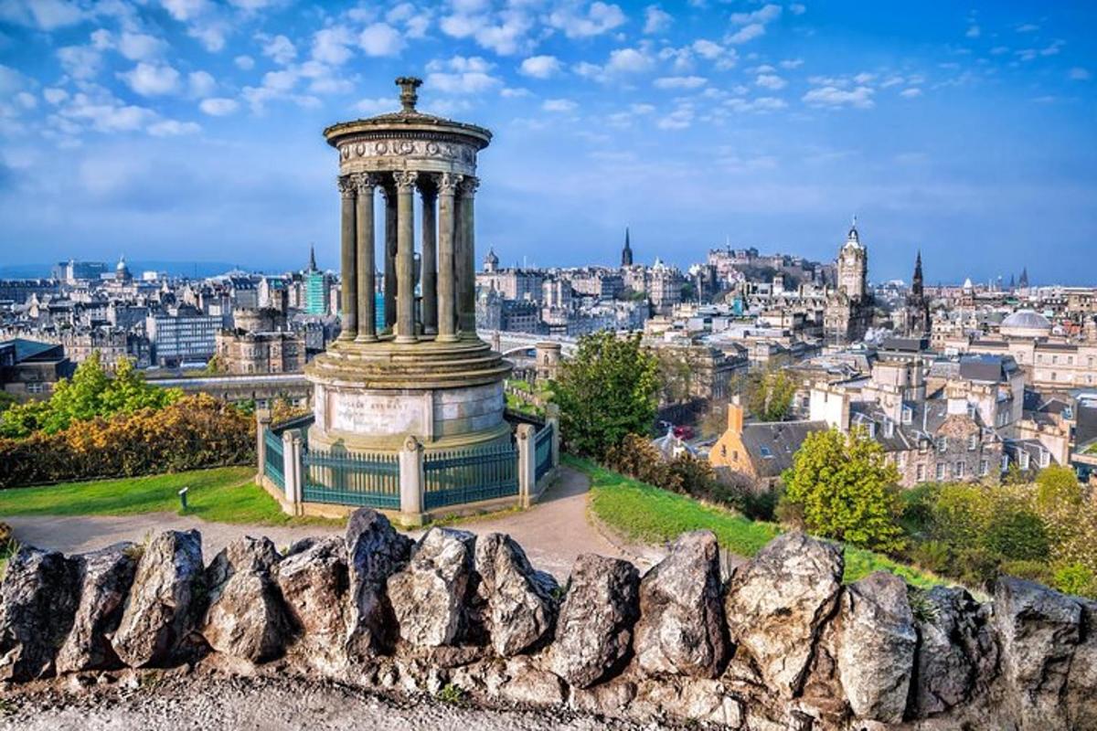 um monumento em uma colina com uma cidade ao fundo