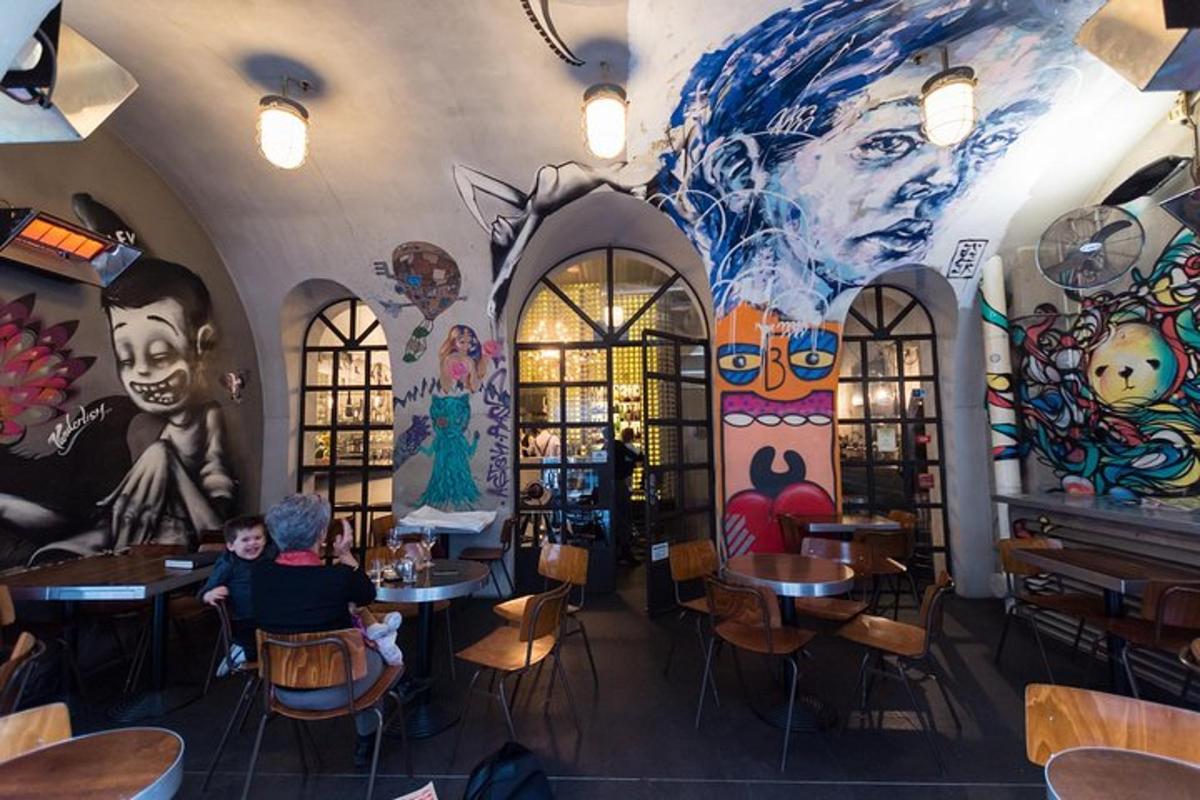 restaurace s nástěnnou malbou na zdi a lidmi sedícími u stolů