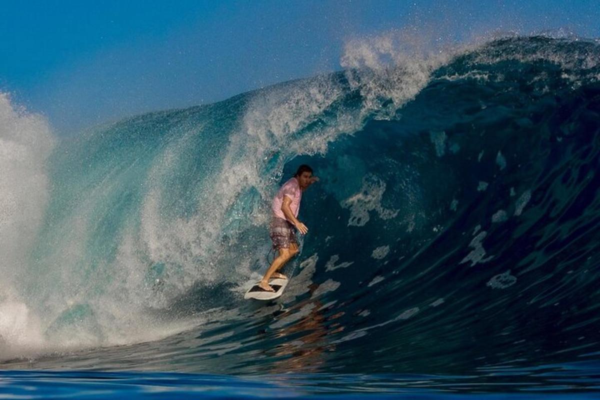 um homem pegando uma onda em uma prancha de surfe no oceano