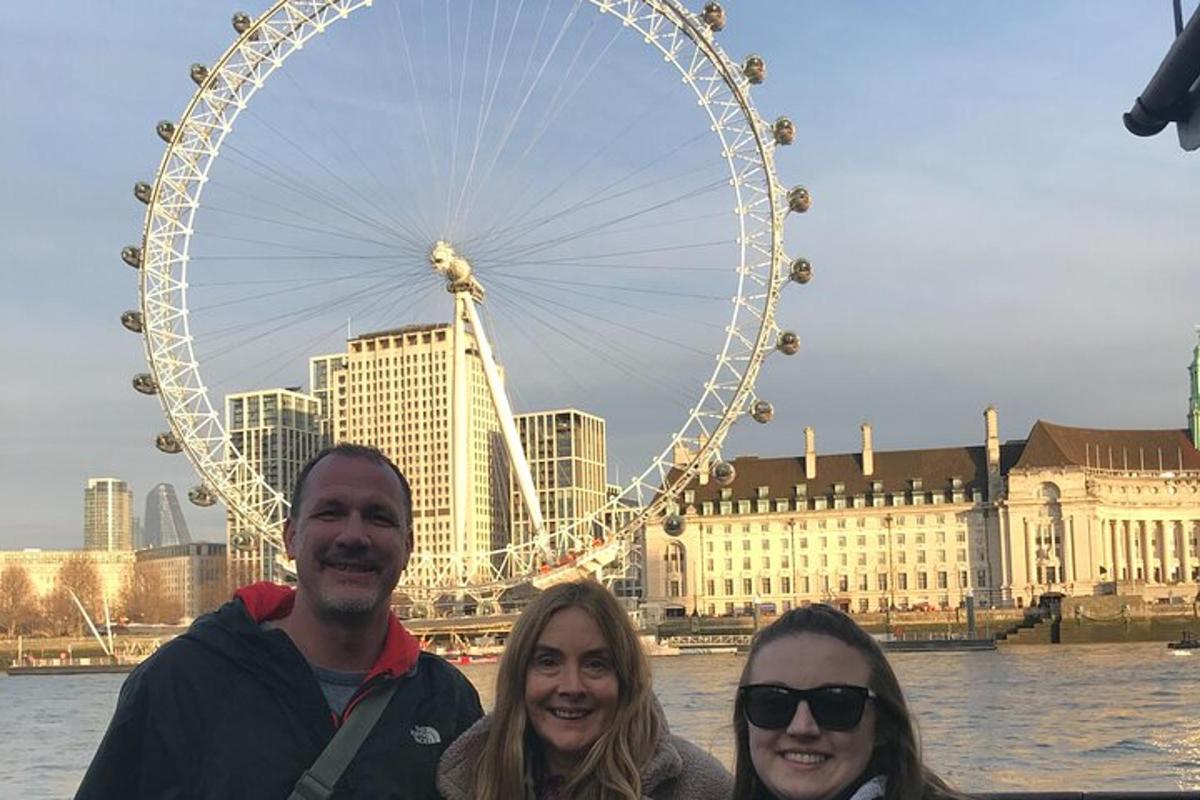 tre persone in piedi davanti a una ruota panoramica