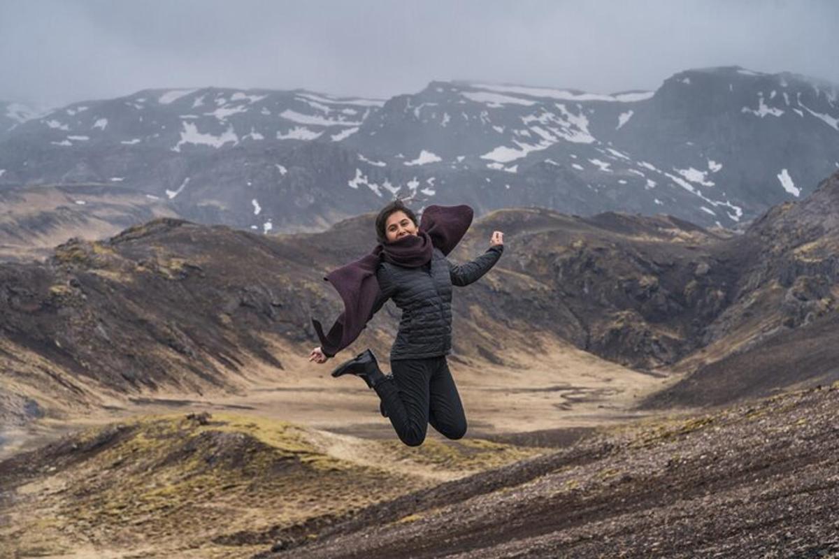 kona hoppar í loftinu yfir fjall