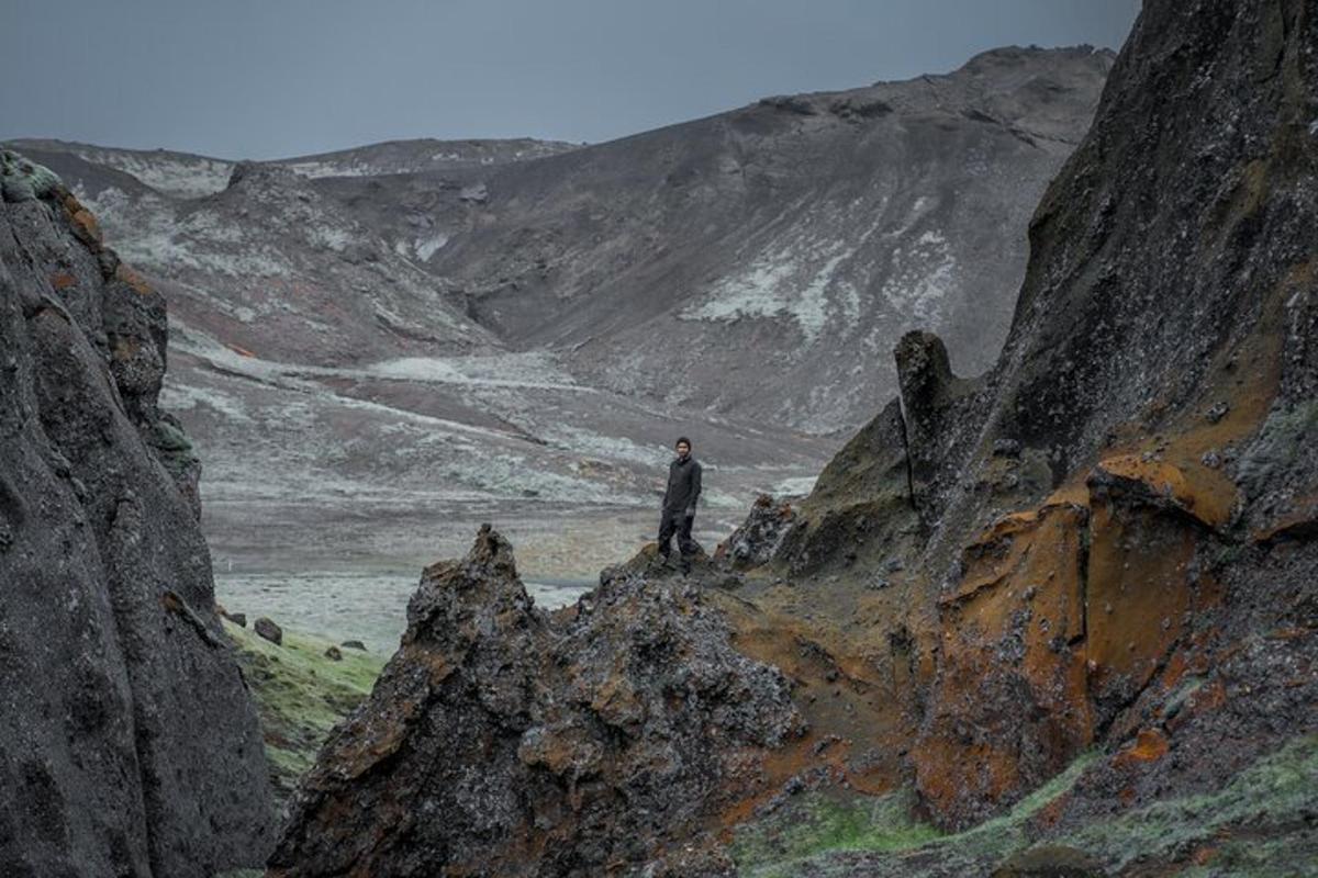maður stendur á toppi grýtts fjalls