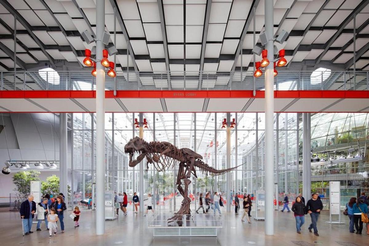 a dinosaur statue in a building with a crowd of people