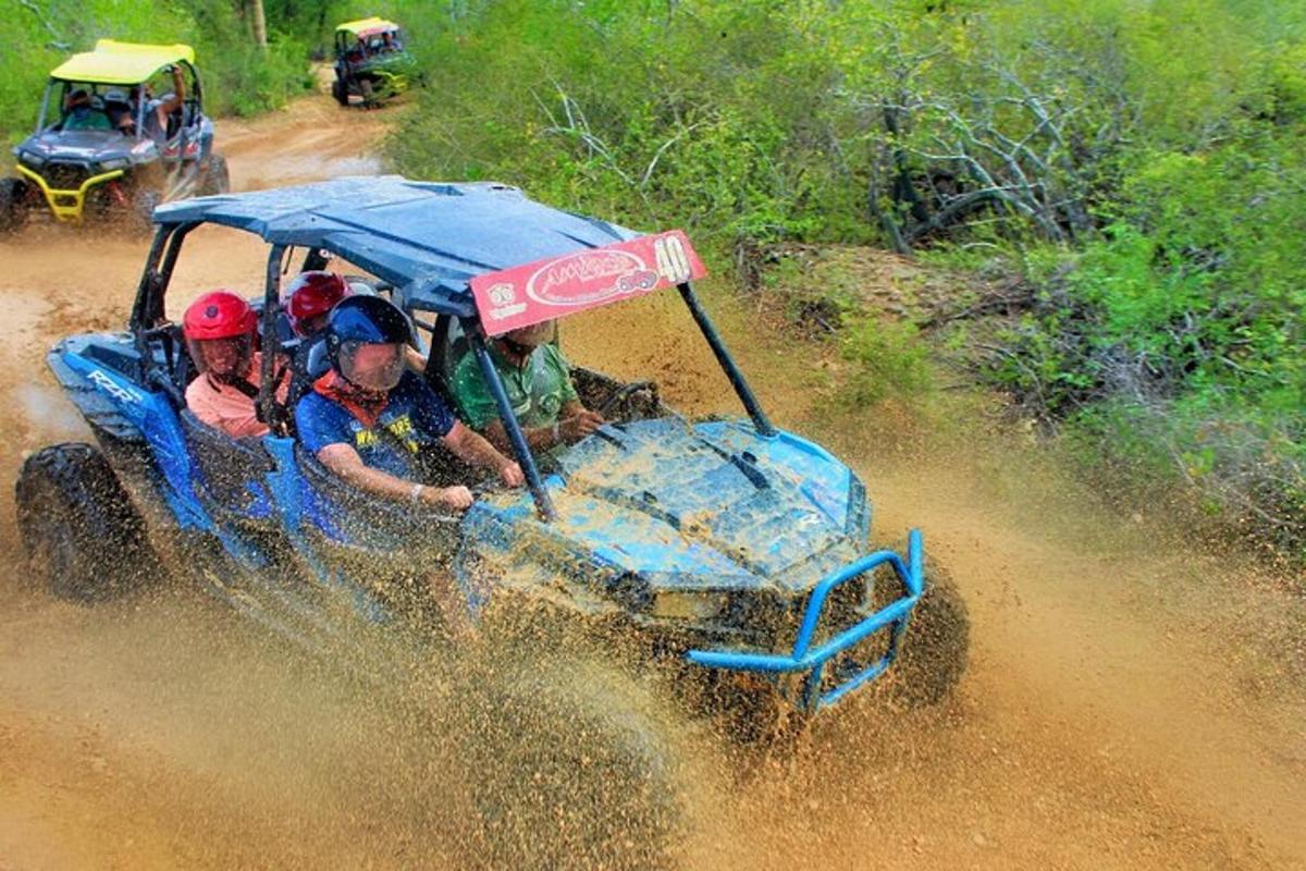 isang grupo ng mga tao na nakasakay sa isang asul na atv sa putikan