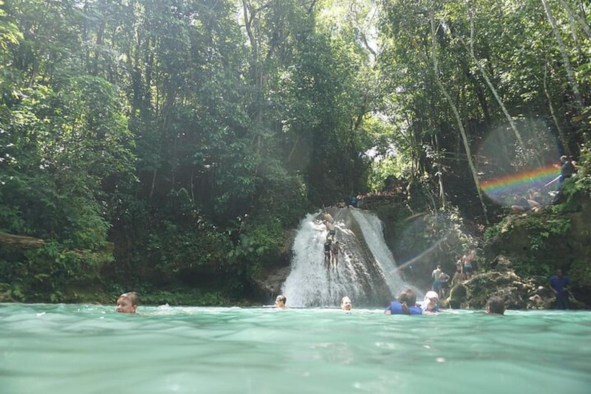 een groep mensen in het water voor een waterval