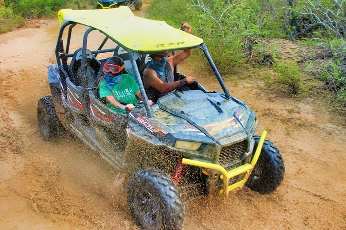 isang grupo ng mga tao na nakasakay sa isang atv sa putikan