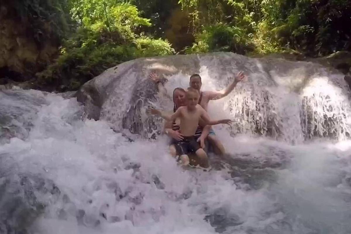 two men playing in the water in a waterfall