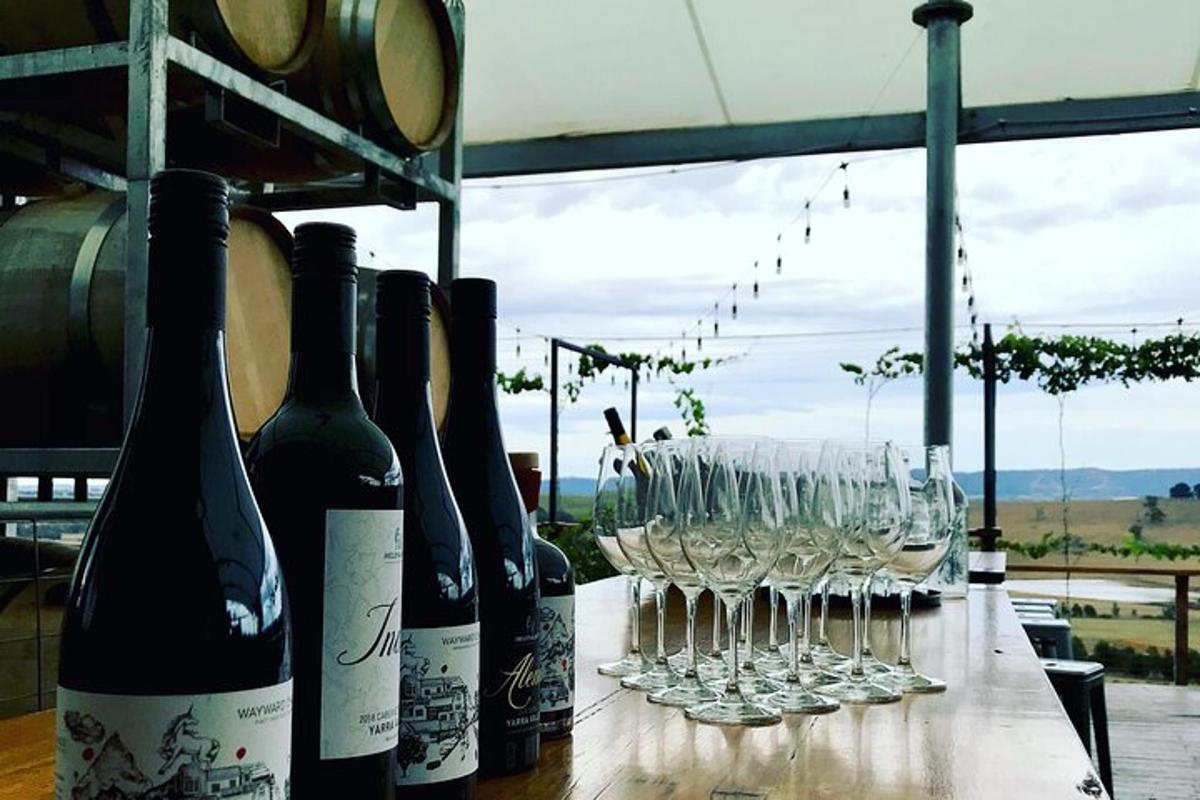 uma fileira de garrafas de vinho e copos sobre uma mesa