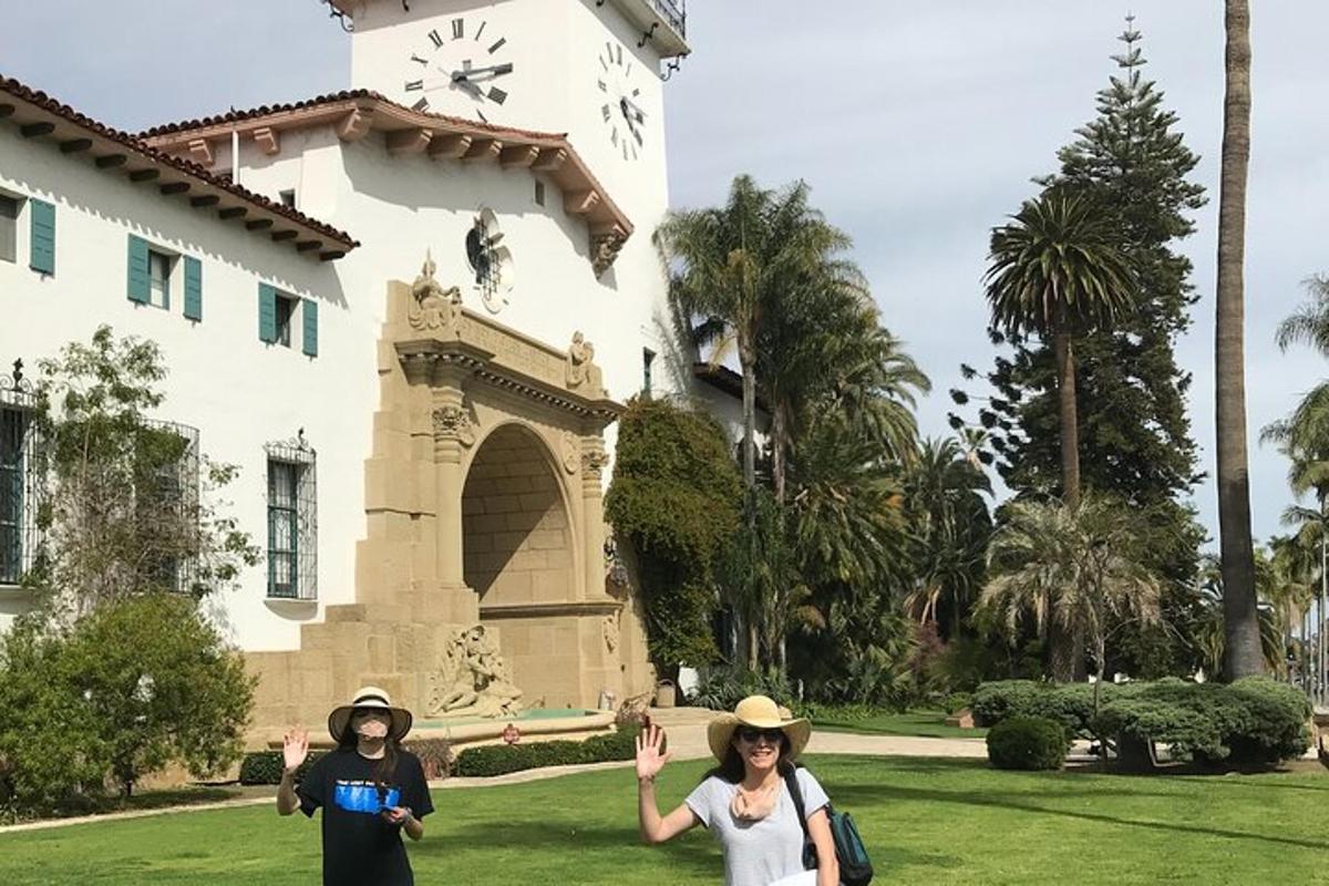 two people standing in front of a building with a clock
