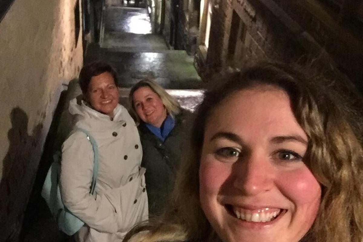 žena a dva muži stojící v uličce