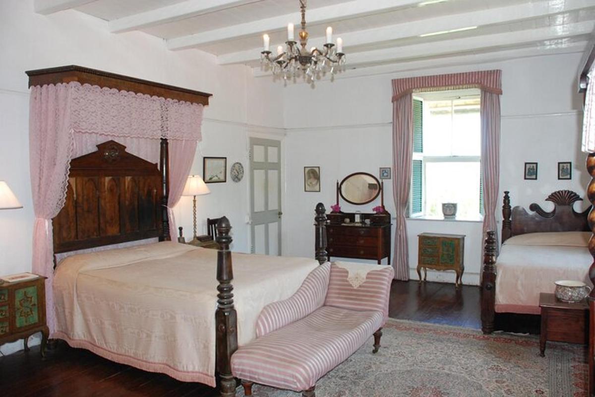 a bedroom with two beds and a chair and a chandelier