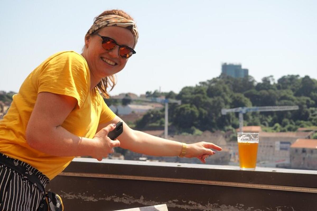 Una mujer sosteniendo un teléfono celular y un vaso de cerveza.