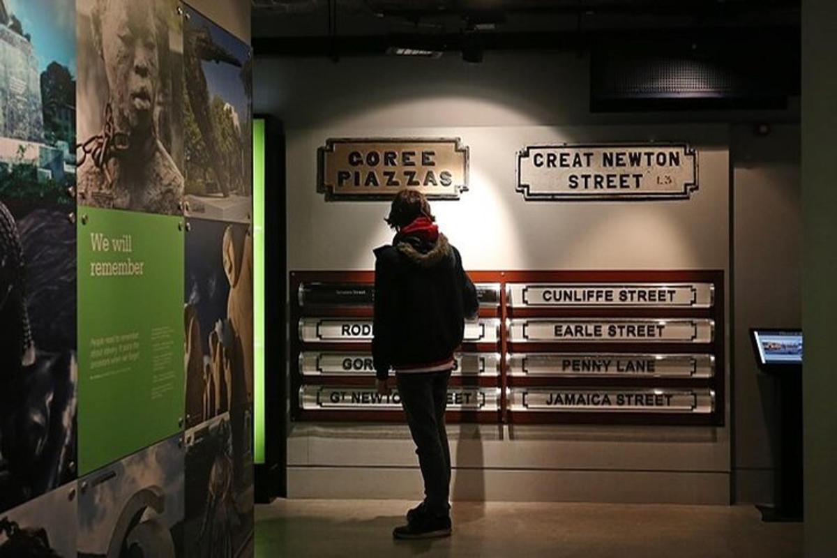 a person standing in a museum looking at signs