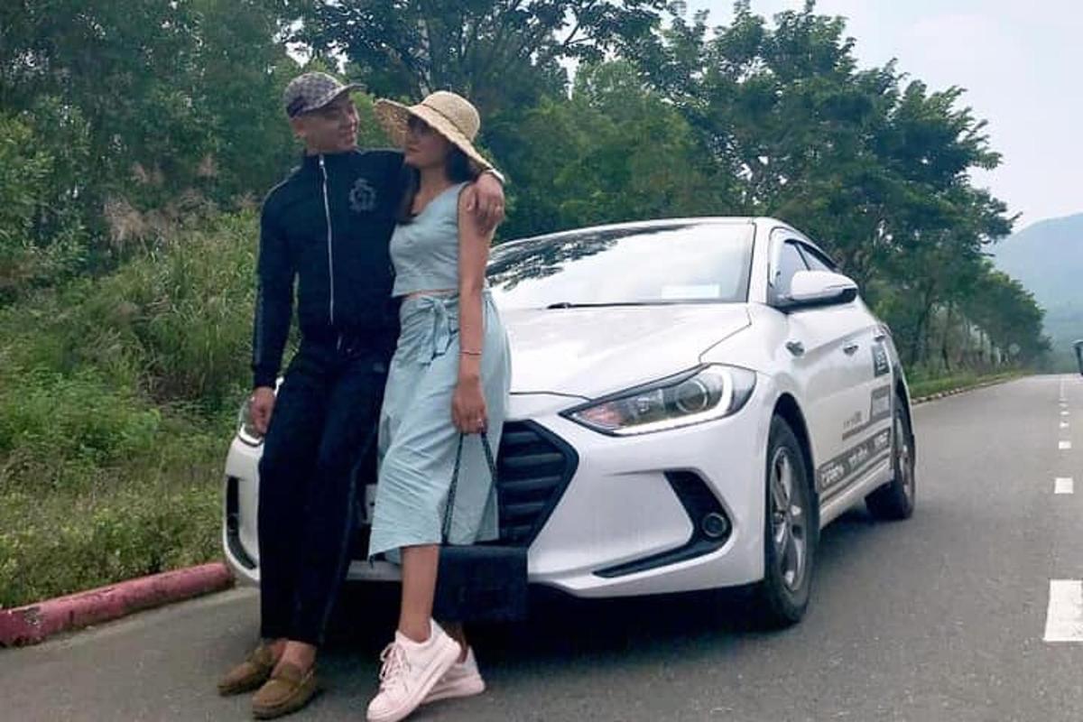 um homem e uma mulher parados ao lado de um carro branco