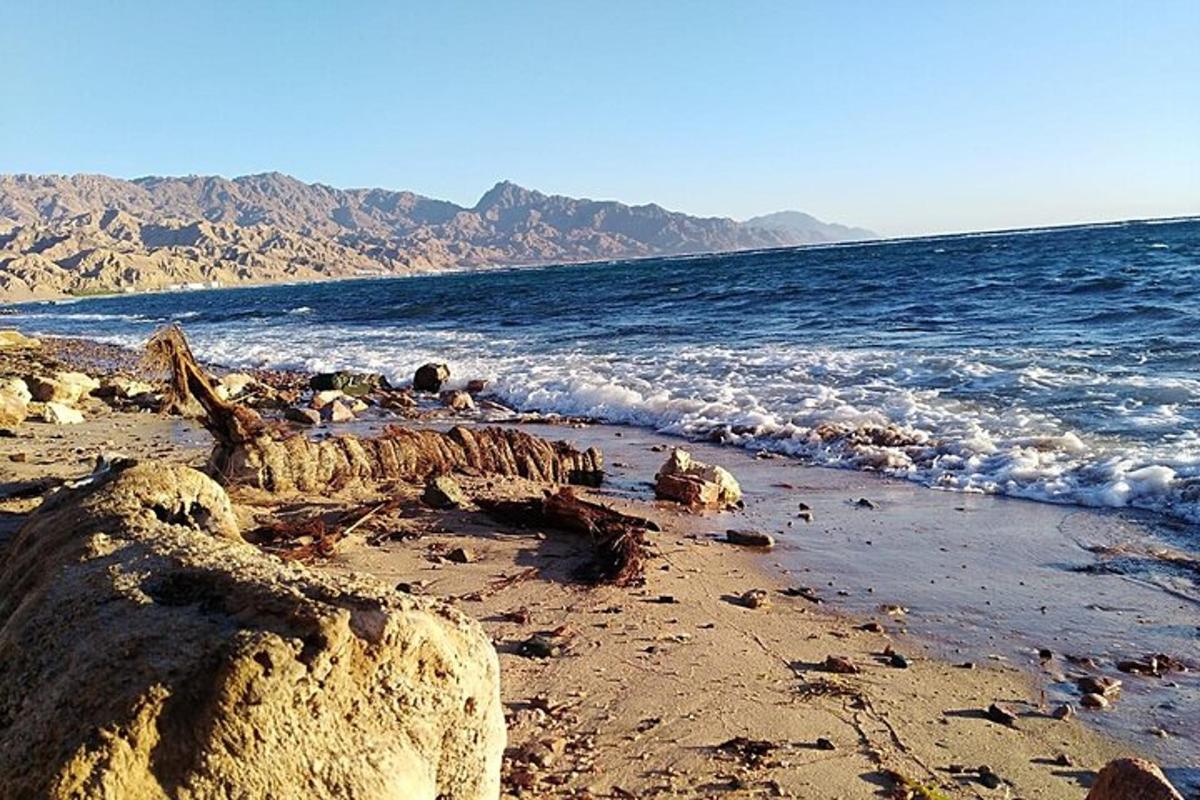 a sandy beach with the ocean and waves