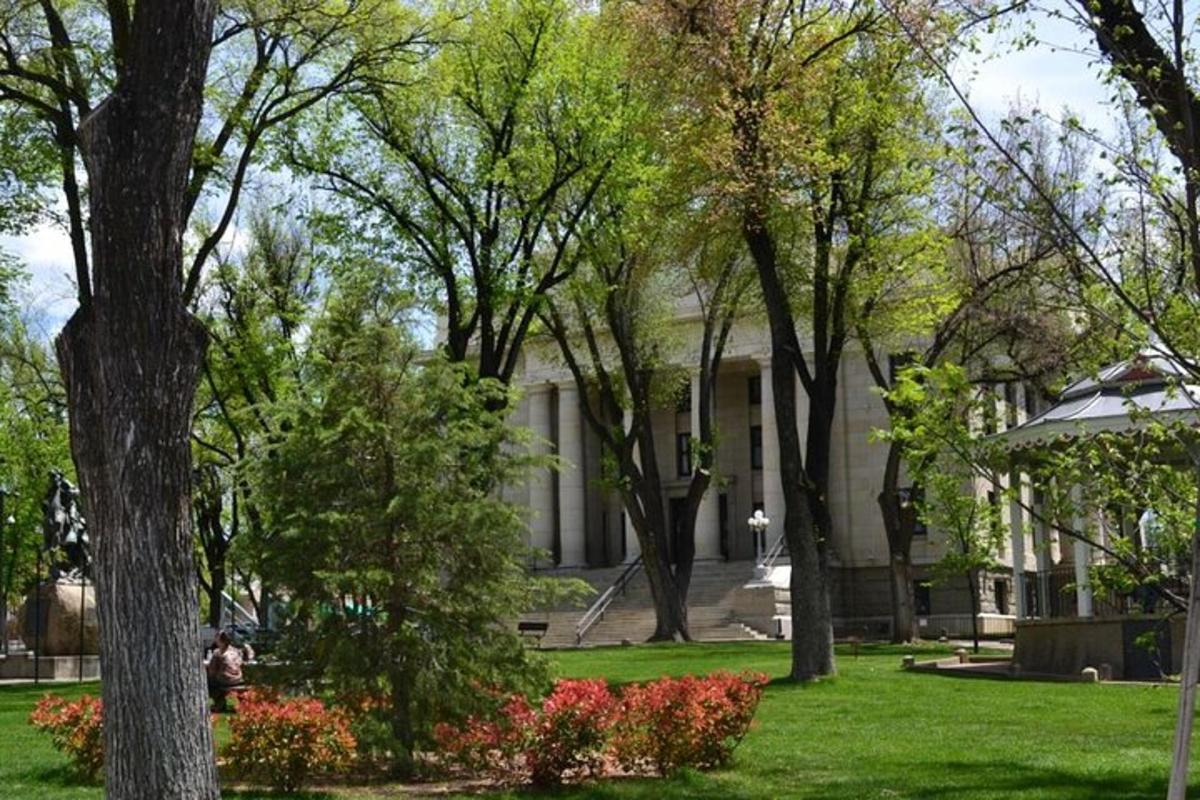 un edifici blanc amb arbres i flors en un parc