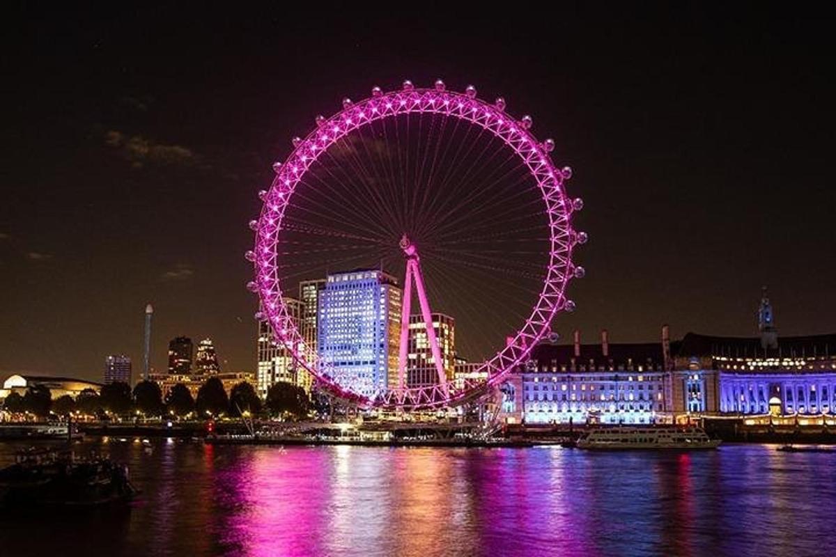 a ferris wheel lit up in purple at night