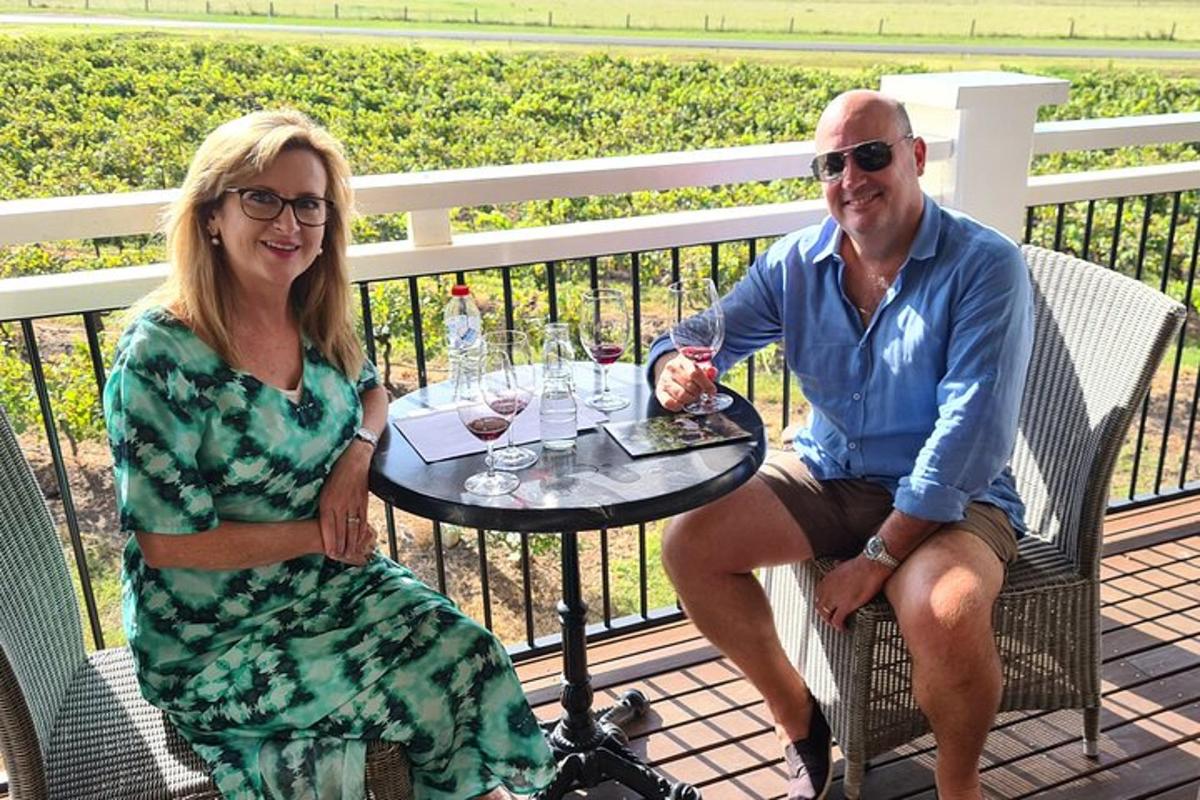 a man and a woman sitting at a table with wine glasses